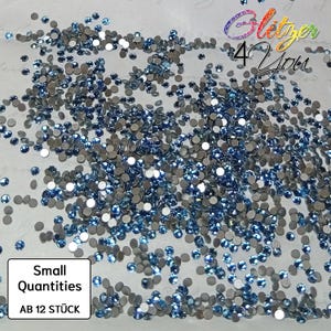 May include: A collection of small, round, blue and silver rhinestones. The image features the text "Glitzer 4 You" in a colourful, cursive font, and "Small Quantities AB 12 STÜCK" in a white box.