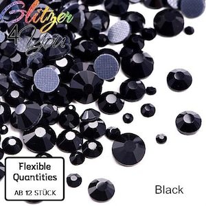 Könnte beinhalten: Eine Ansammlung runder, facettierter schwarzer Strasssteine in verschiedenen Größen. Das Bild enthält den Text Glitzer 4 You, Flexible Quantities, AB 12 STÜCK und Black. Die Steine haben eine glänzende, dunkle Oberfläche und eine graue Rückseite.