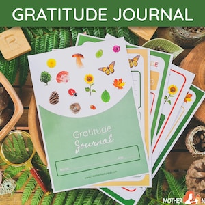 May include: A green and white gratitude journal with a nature-themed design. The cover features illustrations of a mushroom, a ladybug, a bird's nest, a sunflower, and leaves. The journal has a space for a name and age. The text on the cover reads "Gratitude Journal" and "www.MotherNatured.com".