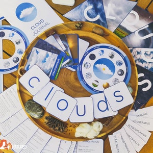 May include: A wooden tray with a blue and white cloud themed educational game. The game includes cards with different types of clouds, a wheel with cloud names, and letter tiles that spell out the word "clouds".