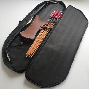 May include: A black archery case with a brown leather quiver and arrows inside. The case is open and the arrows are visible.