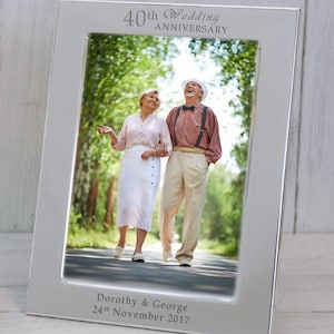 May include: Silver photo frame with a picture of an older couple walking down a path. The frame is engraved with "40th Wedding Anniversary" and "Dorothy & George 24th November 2017".