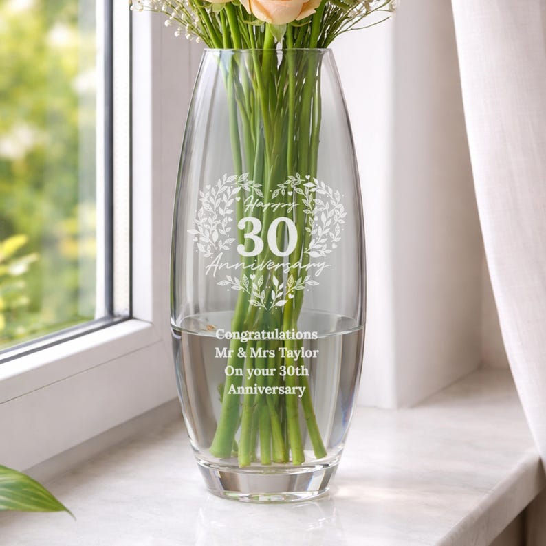 May include: A clear glass vase with an oval shape, featuring an etched design of a heart made of leaves surrounding the text Happy 30 Anniversary. Below this, the text reads Congratulations Mr & Mrs Taylor On your 30th Anniversary.