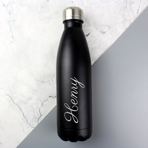 May include: A black stainless steel water bottle with a silver lid. The bottle has the name "Henry" engraved on it.