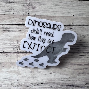 May include: A white sticker with a black dinosaur illustration and the text "Dinosaurs didn't read. Now they are EXTINCT".  The dinosaur is walking and has footprints behind it.