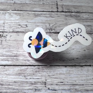 May include: A white sticker with a bee design and the word "KIND" with a dotted line trailing behind the bee.