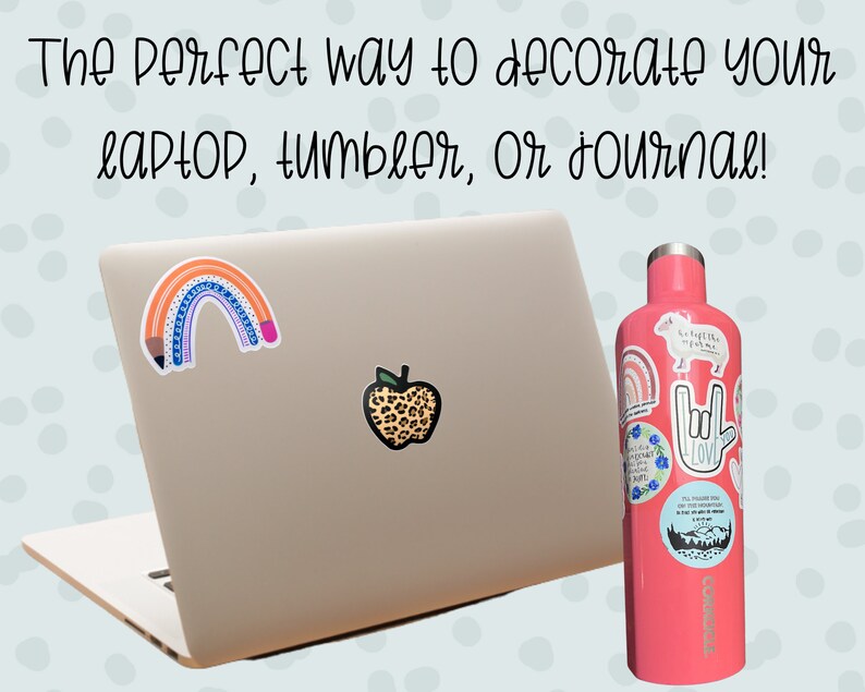 May include: A pink water bottle with various stickers, including a rainbow, a hand sign, and a pig. The bottle is next to a closed laptop with two stickers, a rainbow pencil and a leopard print apple.