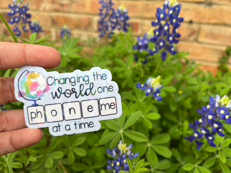 May include: A sticker with a watercolor globe and the text "Changing the world one phoneme at a time."