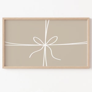 May include: A framed print with a beige background and a white line drawing of a bow tied with string.
