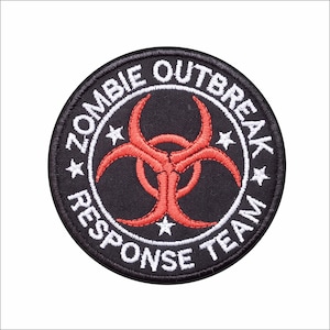 May include: Black and red embroidered patch with the text "Zombie Outbreak Response Team" in a white circle with four white stars. A red biohazard symbol is in the center of the patch.