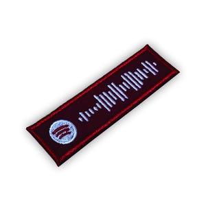 Op de afbeelding: Een rood en wit geborduurd patch met een Spotify-logo en een wit barcode-achtig ontwerp.