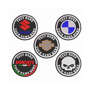 Può includere: Cinque toppe rotonde ricamate in nero e bianco con diversi loghi di motociclette. I loghi includono Suzuki, BMW, Harley Davidson, Ducati e un teschio. Ogni toppa ha il testo "TEXT HERE" e "YOUR NAME HERE" attorno al logo.