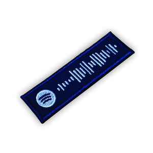 Op de afbeelding: Een blauwe en witte geborduurde patch met een Spotify-logo en een barcode-achtig ontwerp.