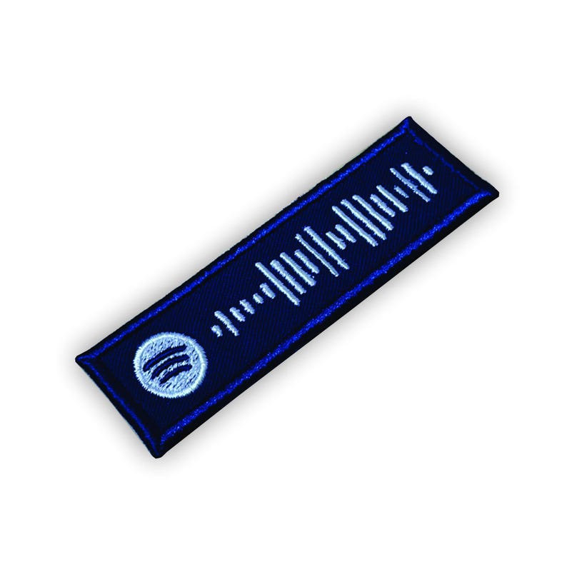 Op de afbeelding: Een blauwe en witte geborduurde patch met een Spotify-logo en een barcode-achtig ontwerp.