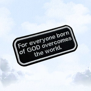Puede incluir: Parche bordado negro con texto blanco que dice "For everyone born of GOD overcomes the world."
