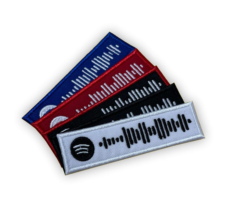 Op de afbeelding: Set van vijf geborduurde patches met een Spotify-logo en een barcode-ontwerp. De patches zijn in wit, zwart, rood en blauw.