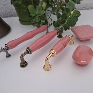 Puxador e botão vintage em porcelana rosa com acabamento em bronze antigo, cobre, cromo preto e prata.