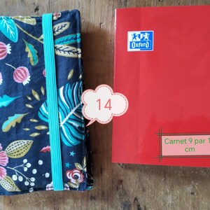 May include: A floral patterned notebook cover with a teal elastic band next to a red notebook. The red notebook has the Oxford logo and the text "Carnet 9 par 14 cm". The notebook is approximately 3.5 x 5.5 inches.