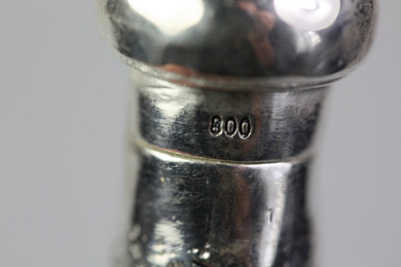 May include: Close-up of a silver object with the number "800" stamped on it.