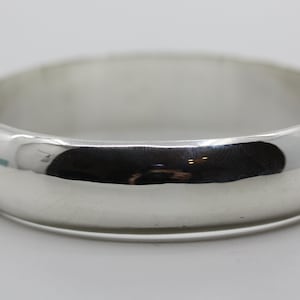 May include: A silver bangle bracelet with a smooth, polished finish.