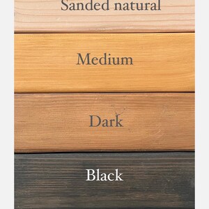 May include: A vertical image showcasing four wood stain color options: Sanded natural, Medium, Dark, and Black. Each color is displayed on a horizontal wooden plank, with the color name printed above. The wood grain is visible in each sample.