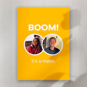 Op de afbeelding: Een gele kaart met de tekst "BOOM!" in wit. Onder de tekst staan twee ronde profielfoto's van een vrouw en een man. De tekst "It's a match." staat onder de foto's.