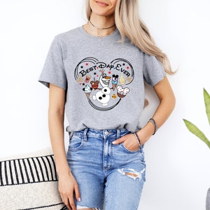 May include: Gray t-shirt with a Mickey Mouse ear design featuring Olaf from Frozen, Mickey Mouse, Minnie Mouse, and other Disney characters. The text "Best Day Ever" is written inside the Mickey Mouse ears.