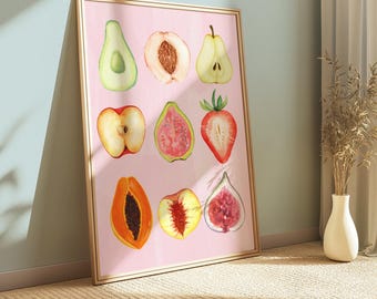 May include: A framed watercolor print featuring nine different sliced fruits on a pink background. The fruits include an avocado, peach, pear, apple, guava, strawberry, papaya, peach, and fig. The frame is a light wood color.