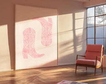 Può includere: Un'opera d'arte incorniciata di grandi dimensioni con due stivali da cowboy rosa con disegni floreali. Gli stivali sono ambientati su uno sfondo chiaro, creando un'estetica morbida e femminile. La stanza ha un pavimento in legno e una poltrona rosa.