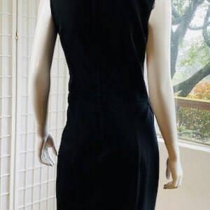 May include: A black sleeveless dress with a scoop neck and a zipper in the back.