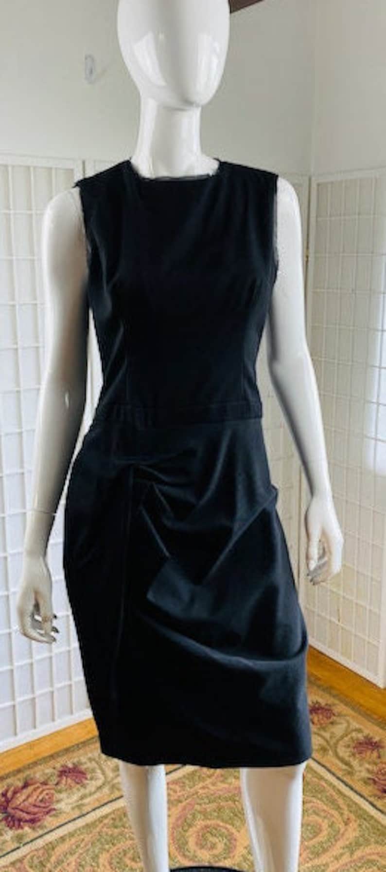 May include: A black sleeveless dress with a gathered skirt and a simple neckline.