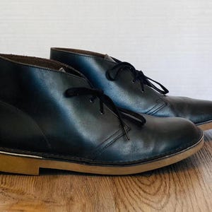 May include: A set of three ceramic mugs with a speckled, matte finish. The mugs are in shades of cream, light gray, and dark gray. Each mug has a simple, minimalist design and a rounded handle.