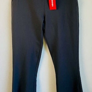 May include: Black flared pants with a red tag that says "Theory" on it.