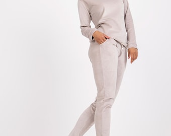 Könnte beinhalten: Ein hellgrauer zweitteiliger Loungewear-Set mit einem Langarmshirt und einer passenden Jogginghose. Das Set ist aus einem weichen, bequemen Stoff gefertigt.