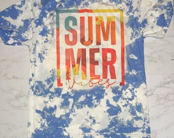 Puede incluir: Una camiseta azul tie-dye con un gráfico colorido que dice "SUMMER vibes" en un cuadro.