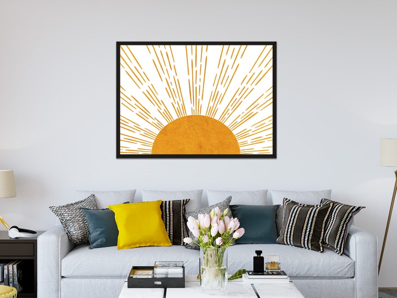 Puede incluir: Una impresi&oacute;n enmarcada de un sol estilizado con rayos naranjas sobre un fondo blanco. El sol es de color naranja s&oacute;lido.