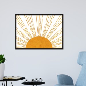 Puede incluir: Una impresi&oacute;n enmarcada de un sol estilizado con rayos amarillos y naranjas que irradian hacia afuera desde un c&iacute;rculo amarillo dorado.