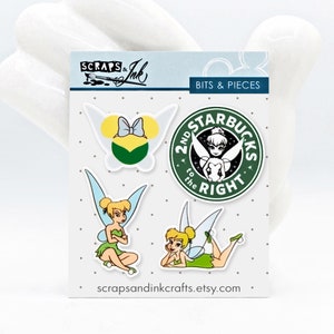 May include: A set of four green and white stickers featuring Tinkerbell and a Starbucks logo. The stickers say "2nd to the right" and "Starbucks". The stickers are on a white background with black polka dots.