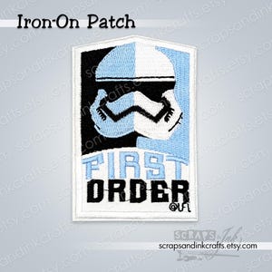 May include: Embroidered iron-on patch with a First Order Stormtrooper helmet design in black, white, and light blue. The text "FIRST ORDER" is below the helmet. The patch is rectangular with a white border.