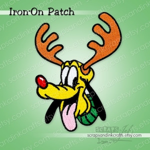 May include: Embroidered iron-on patch depicting a cartoon dog with orange antlers, a red nose, and a pink tongue. The patch is yellow, black, and white with green accents. The text "Iron-On Patch" is at the top.