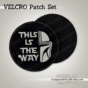 Könnte beinhalten: Ein schwarzes, rundes Klettverschluss-Patch-Set mit dem Text "THIS IS THE WAY" in Weiß und einem weißen Helmdesign. Das Set enthält einen passenden schwarzen Klettverschluss-Rückseiten-Patch. Der Text "VELCRO Patch Set" steht oben.