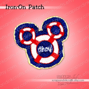 May include: An iron-on patch in the shape of Mickey Mouse's head, featuring a nautical design. The patch has a blue background with red and white life preserver details and the word "ahoy!" in white. The patch is outlined in gold.