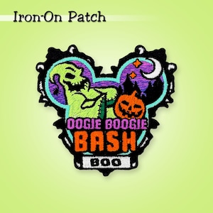 May include: Embroidered iron-on patch featuring a green, skeletal character and an orange jack-o'-lantern. The patch is shaped like a mouse head with the words "DOOGIE BOOGIE BASH" and "BOO". The patch has a black border and is set against a light green background.