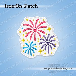 May include: An embroidered iron-on patch featuring three colourful firework bursts in pink, purple, and blue, each with a small mouse-ear silhouette at the centre. The design is accented with small yellow stars and dots on a white background.