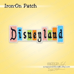 May include: An embroidered iron-on patch featuring the word "Disneyland" in a colorful, retro design. The patch has a rectangular shape with the letters of the word in individual vertical blocks of color, including pink, blue, green, and orange. The text "Iron-On Patch" is above the design.