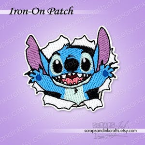 May include: An iron-on patch featuring the character Stitch from Lilo & Stitch, bursting through a torn paper effect. The patch is primarily blue with black, white, and pink accents. The text "Iron-On Patch" is at the top.