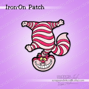 May include: An embroidered iron-on patch featuring a cat with pink and white horizontal stripes, depicted standing on its head with a wide, toothy grin, yellow eyes, and a curled tail. The text Iron-On Patch is visible at the top of the image.