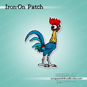May include: An embroidered iron-on patch featuring a cartoon rooster with a bright red comb, yellow neck feathers, and a blue body with a long, curved blue tail. The rooster has large, wide eyes and light gray legs. The text Iron-On Patch is visible.