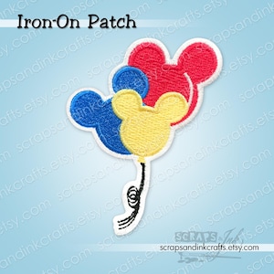 Può includere: Una toppa termoadesiva con tre palloncini a forma di testa di Topolino in rosso, blu e giallo. I palloncini sono collegati da un filo nero con un bordo bianco. Il testo "Iron-On Patch" è in alto.