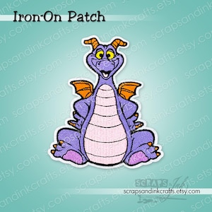 May include: Embroidered iron-on patch featuring a purple dragon with orange wings and yellow eyes. The dragon is sitting with its legs crossed. The patch has the text "Iron-On Patch" at the top. The patch is from scrapsandinkcrafts.etsy.com.